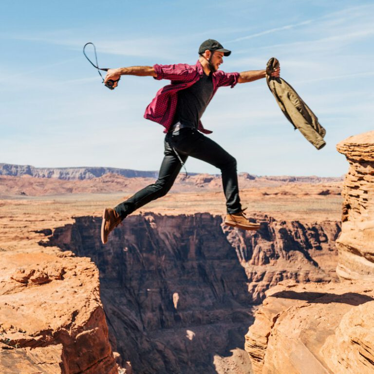 man jumping on rock formation